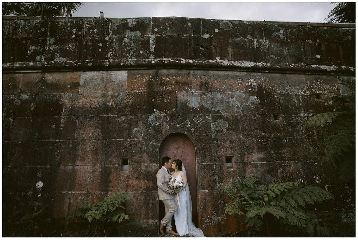 Bride and groom in front of the historic red door at Gunners Barracks Mosman.